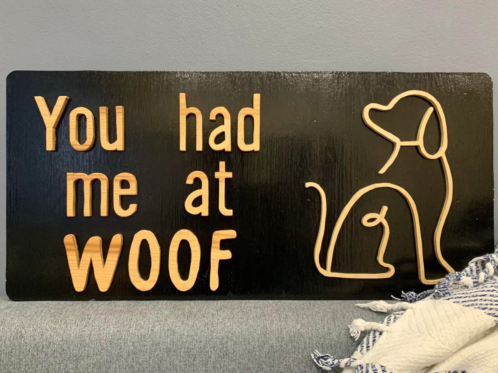 Black wood sign reading You had me at WOOF with a continuous line-art wooden dog
